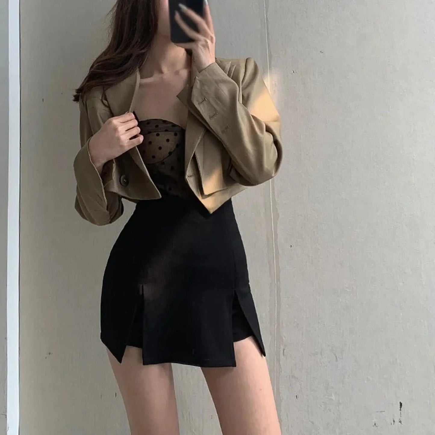 Mujer con minifalda abierta por delante se hace selfie de su conjunto con chaqueta